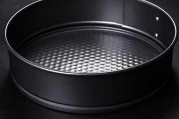 Round cake pan, tray or mould on a black concrete background