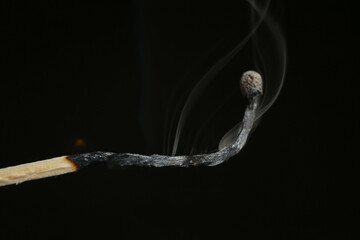 Burnt match with fume on black background. Emotional burnout concept