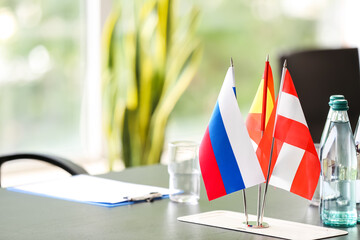 Flags of Austria, Spain and Russia on table in conference room