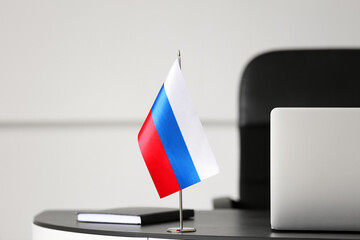 Russian flag and book on dark table in light room
