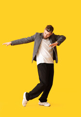 Cool dancing young man on color background