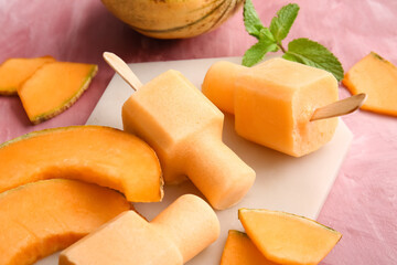 Board with tasty popsicles and melon pieces on pink background