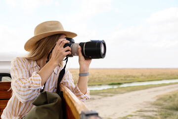 Beautiful female tourist with photo camera on safari