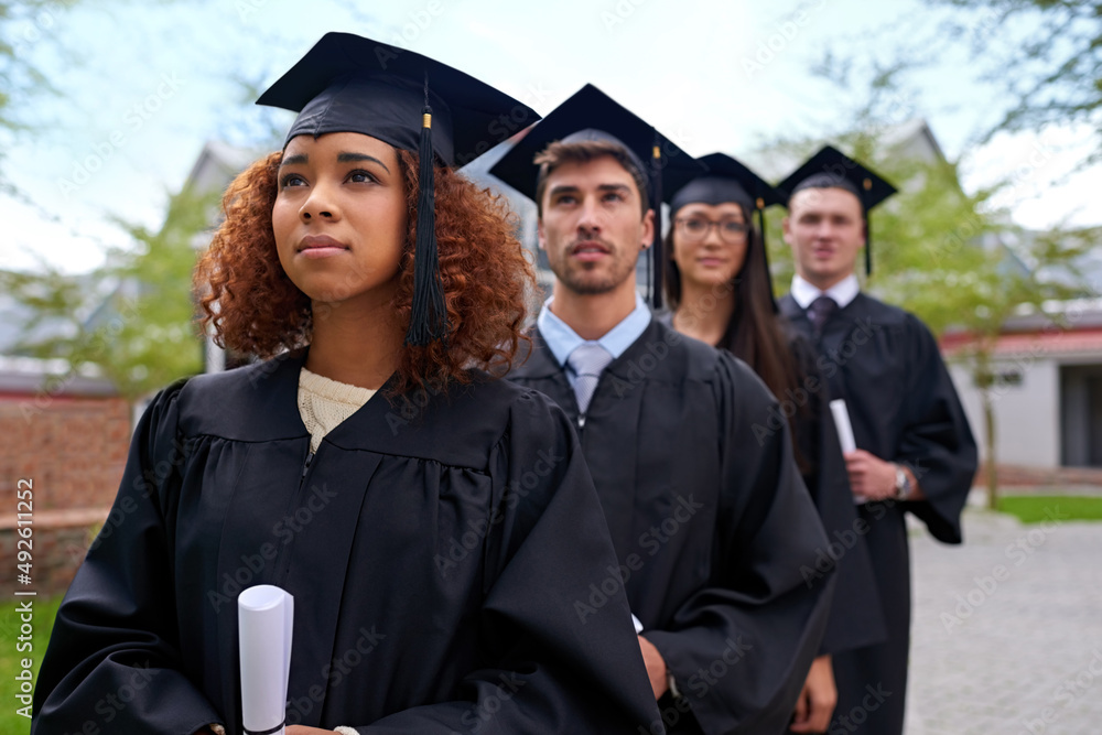 Poster higher education for high aspirations. shot of graduating university students standing in a row look