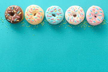 Different sweet donuts on color background