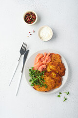 Potato pancakes. Fried homemade potato pancakes or latkes with cream, green onions, microgreens, red salmon and sauce in rustic plate on white table background. Rustic style. Healthy food. Top view.