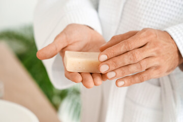 Obraz premium Young man with soap in bathroom, closeup
