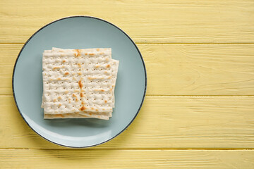 Plate with Jewish flatbread for Passover on color wooden background
