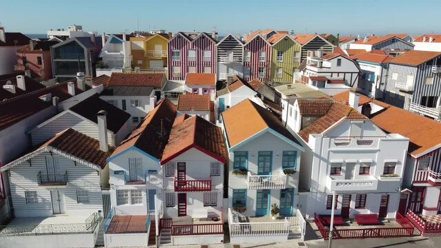 Aerial shot of coloured houses in Costa Nova do Prado in Portugal, Flying sideways in front of the houses from left to the right. Europe, Aveiro