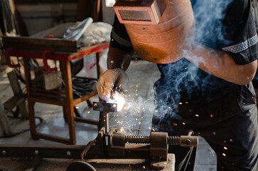 young man doing hobbies welding steel in his workshop Soft focus