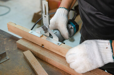 Young man doing woodworking hobby in his workshop, soft focus.