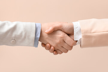 Business colleagues shaking hands on beige background, closeup