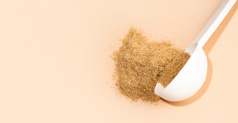 Mixture of dietary fiber supplement . White scoop of dietary fiber on a beige background. Dietary...