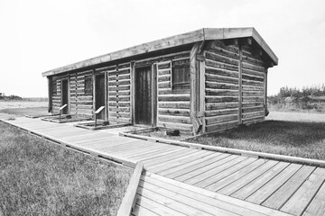 A reconstructed buildings of wood and chink of a trading post from early 1800s in black and white