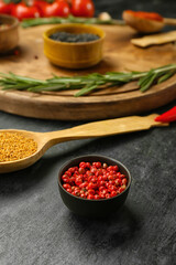 Bowl with red peppercorns on dark background
