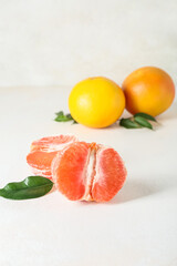Tasty cut grapefruit on light background