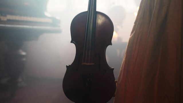A Young Girl And Man Plays The Violin In A Beautiful Retro Room With Flowers And A Piano.