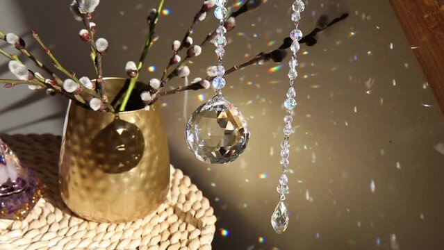 Selective focus on round ball shape crystal rainbow maker suncatcher hanging in home with Orgonite or Orgone pyramid. Good Feng Shui, Sha Chi reflection, energy flow concept. 