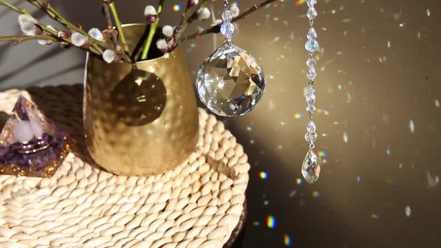 Selective focus on round ball shape crystal rainbow maker suncatcher hanging in home with Orgonite or Orgone pyramid. Good Feng Shui, Sha Chi reflection, energy flow concept. 