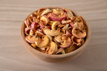 Bowl full of dried apples on a wooden background