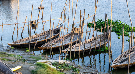 Fototapeta premium A row of parked wooden passenger boats on the river in the rural village