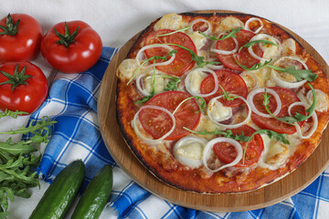 Homemade Pepperoni pizza with Mozzarella cheese, salami, tomato onion, pepper, arugula and spices. Italian cuisine