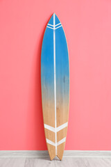 Wooden surfboard near pink wall