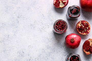 Obraz na płótnie Canvas Jars of pomegranate molasses and fresh fruits on light background