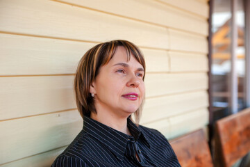  Portrait of   beautiful mature woman on   porch of her house