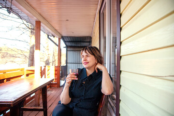  Portrait of   beautiful mature woman on   porch of her house