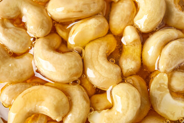 Sweet cashew nuts in honey as background