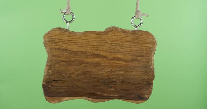Hanging and wobbling old blank direction sign. With space for design, text place. Old wooden board hanging on the ropes