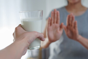Woman refusing or reject glass of milk, Lactose intolerance and health care concept - obrazy, fototapety, plakaty
