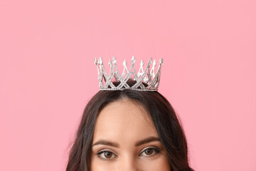 Beautiful young woman in stylish tiara on pink background
