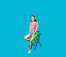 Young asiatic woman wearing wireless bluetooth headphones listening music