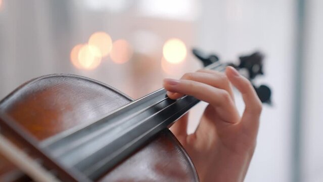 A Young Girl And Man Plays The Violin In A Beautiful Retro Room With Flowers And A Piano.