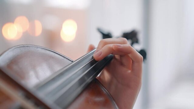A Young Girl And Man Plays The Violin In A Beautiful Retro Room With Flowers And A Piano.