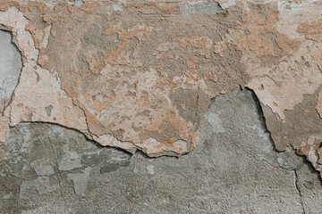 An old cement wall background. A concrete wall texture with cracked beige paint.