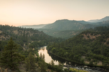 A river flows through mountains, seen from a hill
