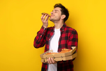 Happy Guy Holding Box Biting Pizza At Studio - obrazy, fototapety, plakaty