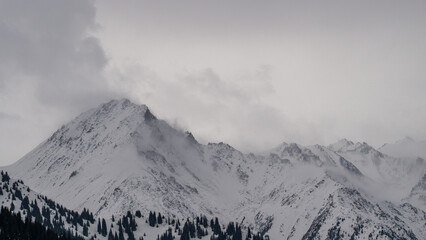 Fototapeta na wymiar Fog and bad weather in snowy mountains