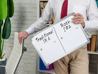Man holds whiteboard with pros and cons for Traditional and Roth IRA.