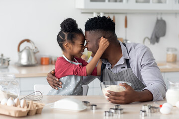 Fototapeta na wymiar Cute little black girl baking with her daddy