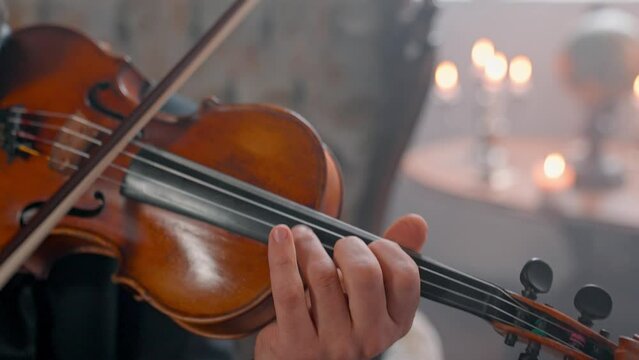 A Young Girl And Man Plays The Violin In A Beautiful Retro Room With Flowers And A Piano.