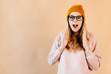 Beautiful girl with a surprised look on her face is broadly smiling. Young woman is posing for a brand cloth. The girl is wearing trendy cloth. Concept of photography