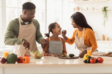 African Family Cooking Having Fun Feeding Each Other In Kitchen