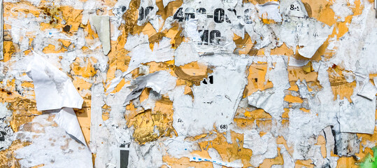 Billboard With Torn Peeled Poster Abstract Background. Outdoor Bulletin Board Or Plywood Panel With Worn Advertising Message, Notice And Stickers Street Texture