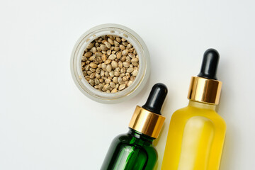 Marijuana cosmetic products, CBD oil. Medicinal cannabis extract in cosmetic bottles on white background. Natural herbal care, medical usage, hemp therapy.