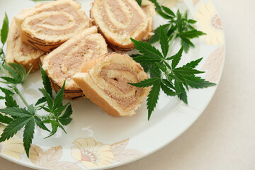 Sweet roll with marijuana oil on white plate. Cannabis kitchen. Layout of delicious dessert, top view close up.