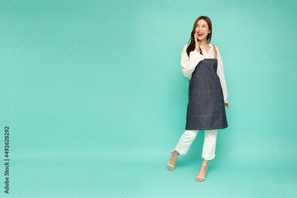 Wall mural Restaurant owner sme young Asian woman is standing and announcing information with hands around mouth isolated on green background